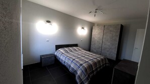 A bedroom with a bed, two wall-mounted lights, a ceiling fan, and a wardrobe. - Casa Appartamento Vacanza La Rondulina Suite (Tigliole)