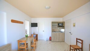 A compact living space with a dining area, a kitchen, and a sleeping area. - Anthoula Village (Hersonissos)