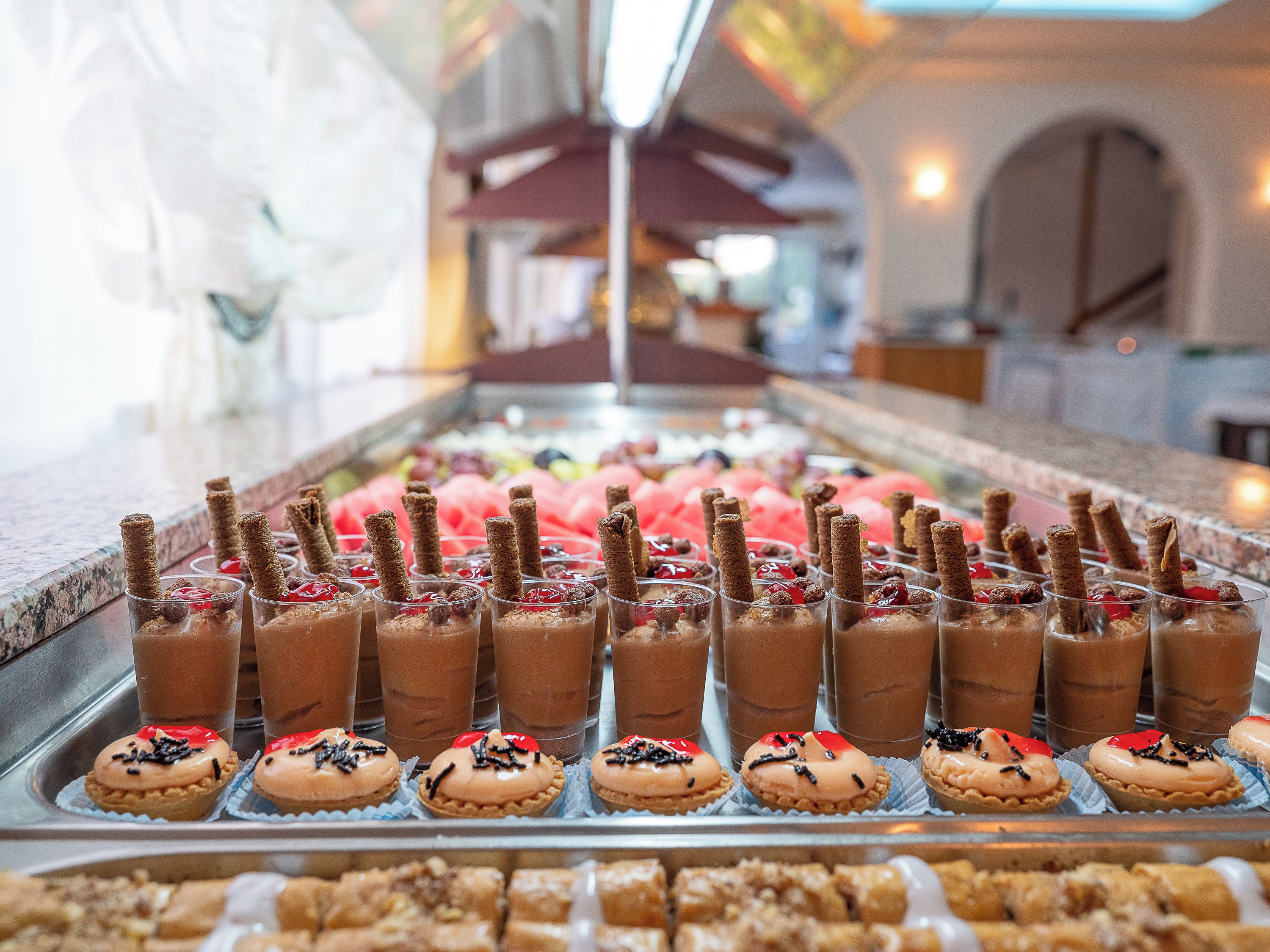 A dessert display with chocolate drinks and decorated pastries.