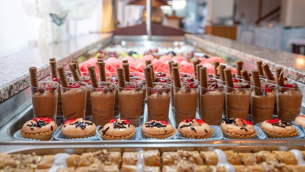 Una exhibición de postres con bebidas de chocolate y pasteles.