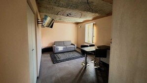 A room with a sofa, a small table, and a ceiling mural. - La Rondulina Classica (Tigliole)