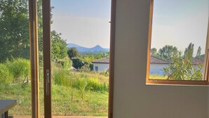 Une pièce dotée d’une porte-fenêtre coulissante donnant sur une terrasse, d’un petit panier en osier et d’une chaise blanche.