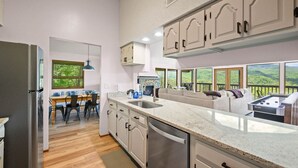 Een moderne keuken met een groot eiland, inbouwapparatuur en uitzicht op de omgeving.