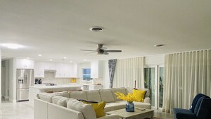 A modern living room with a sofa, coffee table, and a view of the kitchen.