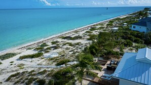 Ein Strandgrundstück mit einer Terrassenfläche, einem Pool und Blick auf den Ozean.