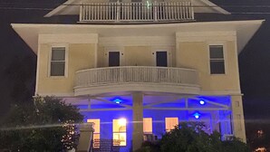 A two-story house with a balcony, a covered front porch, and a staircase leading to the second floor. - Great place for a large family reunion! (New London)