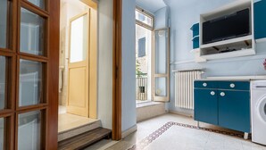 Ett modernt kök med en inbyggd tvättmaskin, ett stort fönster och en trädörr.