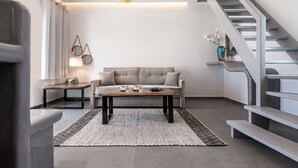 Ein modernes Wohnzimmer mit einer Couch, einem Couchtisch und einer Treppe.