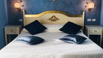 A bed with a white quilted bedspread, two dark pillows, and a tufted headboard.