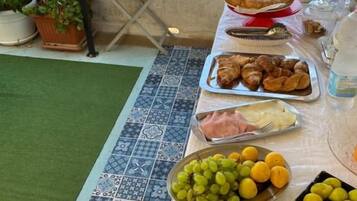 A table with various food items including fruits, pastries, and a watermelon.