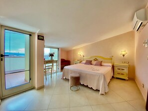 Un dormitorio con cama, mesitas de noche, una silla y vistas a través de una puerta.