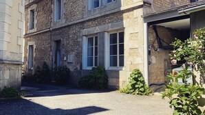 A two-story stone building with multiple windows, a garage, and a clear sky. - Maison Saint Louis (Poitiers)