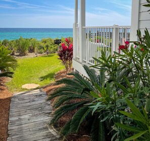 A wooden deck leading to a white porch with a view of the ocean. - Directly on the beach! Your 30A getaway! (Panama City Beach)