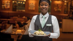 A person in a restaurant holding a plate of food. - The Samuel Hotel, Dublin City Centre (Dublin)