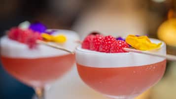 Two cocktails with fruit garnishes.