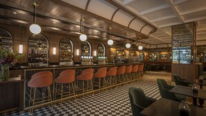 A bar area with a checkered floor, bar stools, and a long counter with shelves of bottles and glasses. - The Samuel Hotel, Dublin City Centre (Dublin)