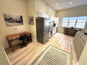 Una cocina funcional con refrigerador, estufa y comedor.
