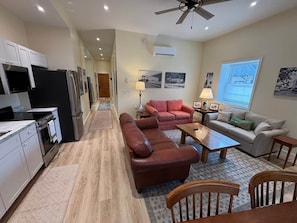 Un appartement moderne comprenant une cuisine, un salon et un coin repas.