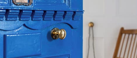A blue door with a brass doorknob and a nameplate.