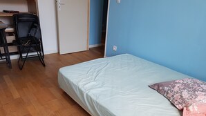 Huone, jossa on sänky, työpöytä ja tuoli.