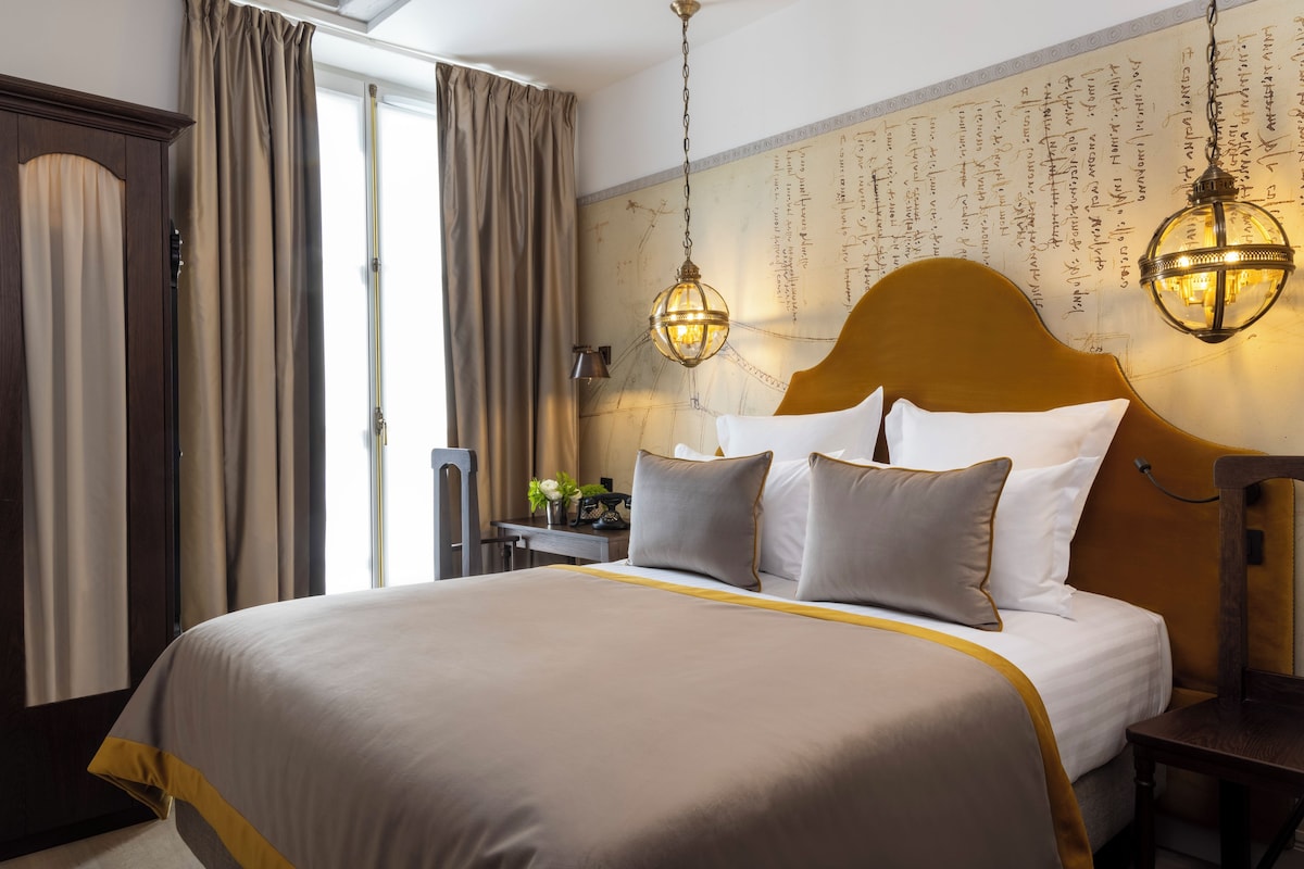 A neatly made bed with a headboard, a bedside table with a lamp, and a wall with a decorative pattern.