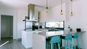 A modern kitchen with a central island, bar stools, and pendant lighting. - MONTE DA FIFAS Countryside house with a pool and a magnificent view over the dam (Montargil)