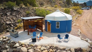 Una estructura de domo geodésico con un pérgola de madera y asientos exteriores.