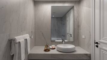 Un baño moderno con un espejo grande, un lavamanos redondo y un perchero para toallas.