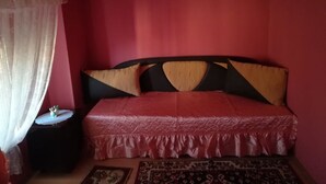 Ein Schlafzimmer mit einem Bett, einem Nachttisch und einem Teppich.
