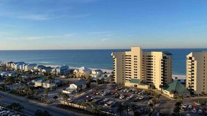 A coastal hotel with multiple high-rise buildings, a parking lot, and a view of the beach. - Newly remodeled Gulf view condo, sleeps six! (Panama City Beach)