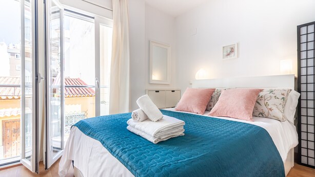 Ein Schlafzimmer mit Bett, Fenster und Tür.