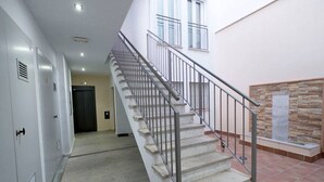 Eine Treppe mit Metallgeländern, die zu einer oberen Etage führt.