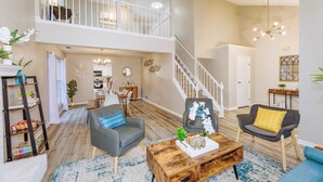 A spacious living area with a high ceiling, a staircase, and a dining area. - Downstairs BR! Pet Friendly house w/4BR, fenced yard & Sun Room (Indianapolis)