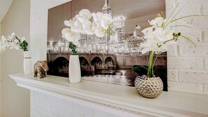 A fireplace mantel with three white vases and a decorative elephant figurine. - Downstairs BR! Pet Friendly house w/4BR, fenced yard & Sun Room (Indianapolis)