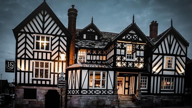 A traditional Tudor-style building with a prominent entrance and a sign indicating a restaurant. - Lion & Swan Hotel (Congleton)