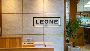 A reception desk with a sign that reads "LEONE" and a sign indicating the reception area. - Lion & Swan Hotel (Congleton)