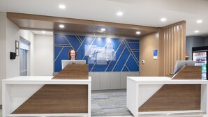 A reception area with a modern design, featuring two reception desks with wooden accents, a blue wall with geometric patterns, and a sign for 'Integration Express'. - Holiday Inn Express and Suites Burley by IHG (Heyburn)