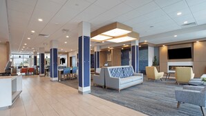A spacious lobby with a reception desk, seating area, and a TV screen. - Holiday Inn Express and Suites Burley by IHG (Heyburn)