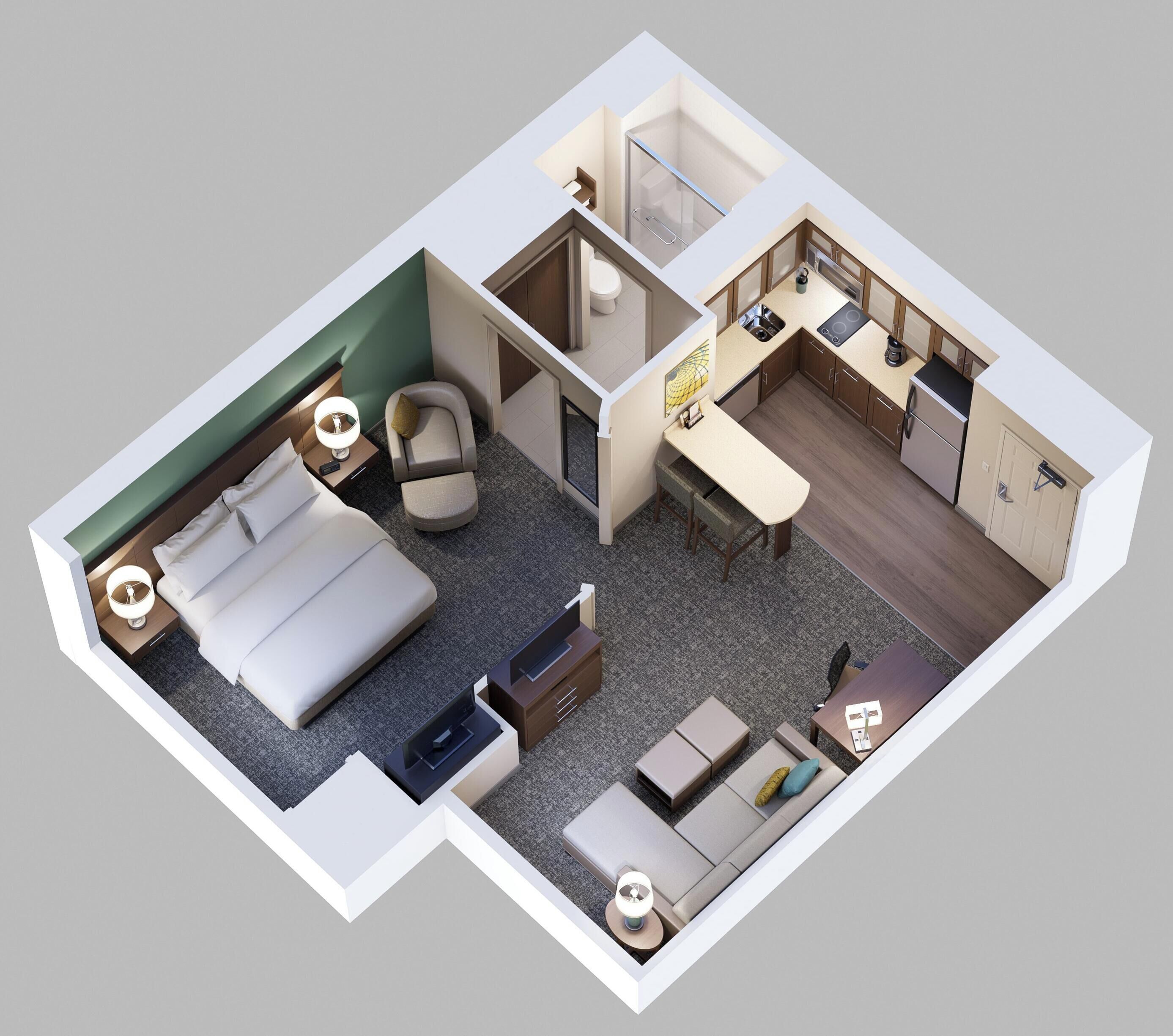 Habitación de hotel con cama, escritorio, sofá, una pequeña cocina y baño.
