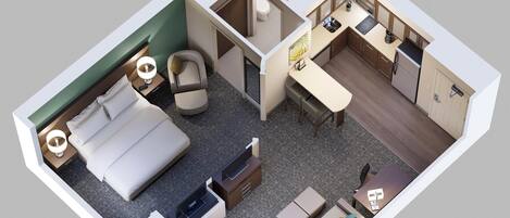 Habitación de hotel con cama, escritorio, sofá, una pequeña cocina y baño.