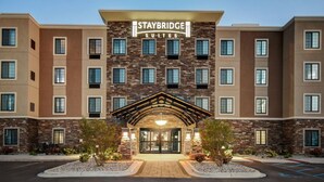 A Staybridge Suites hotel with a stone facade, multiple windows, and a prominent entrance with a covered walkway. - Staybridge Suites Southgate Detroit Area by IHG (Southgate)