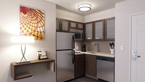 A compact kitchen with a refrigerator, microwave, coffee maker, and a small countertop. - Staybridge Suites Southgate Detroit Area by IHG (Southgate)