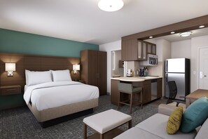 A hotel room with a bed, a desk, a chair, a refrigerator, and a microwave. - Staybridge Suites Southgate Detroit Area by IHG (Southgate)