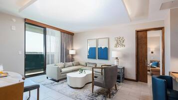 Una sala de estar moderna con un sofá, sillones, una mesa de centro y un comedor con mesa y sillas.