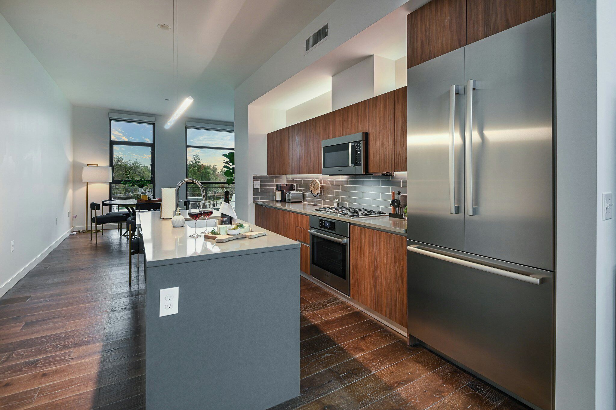 Una cocina moderna con una isla central, electrodomésticos de acero inoxidable y armarios de madera.