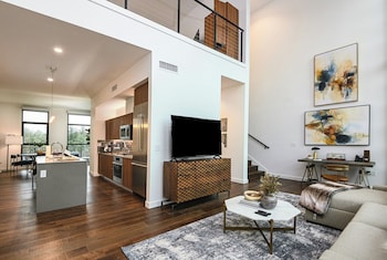A modern living room with a sofa, coffee table, and artwork on the wall. at Drey Hotel