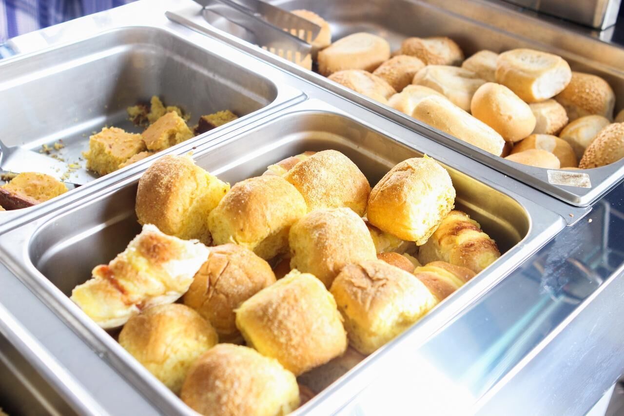 A buffet with various baked goods including bread rolls and pastries.