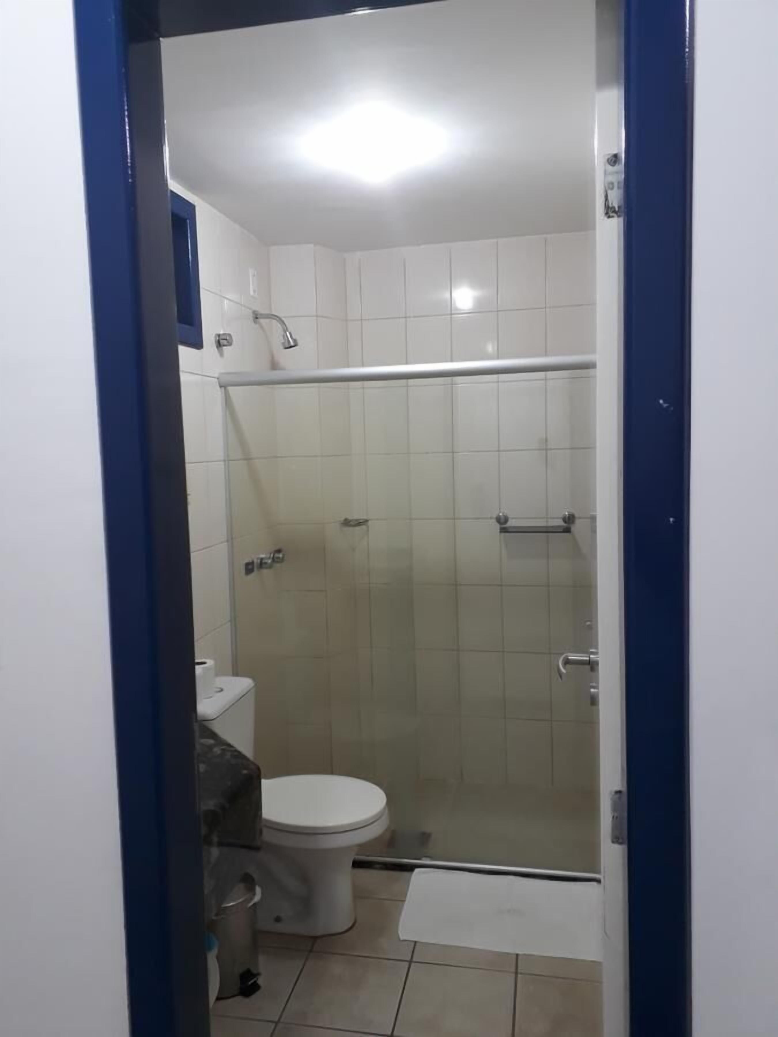 Pieni, erillinen kylpyhuone, jossa on wc, suihku ja pesuallas.