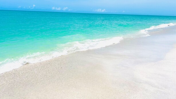 A beach with clear turquoise water and a sandy shore. - Pet-Friendly Island Home | Pool, Hot Tub + Cart (Upper Captiva)