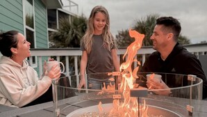 Three people seated around a glass-top table with a built-in fire feature, outdoors. - Pet-Friendly Island Home | Pool, Hot Tub + Cart (Upper Captiva)